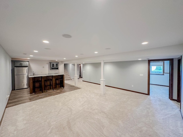 731 Grove Ave, Bird Island, MN 55310 - unfurnished living room with bar with sink, recessed lighting, baseboards, and light colored carpet