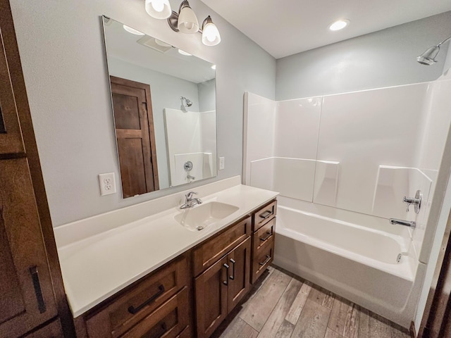 731 Grove Ave, Bird Island, MN 55310 - full bath featuring wood finished floors, vanity, and bathtub / shower combination