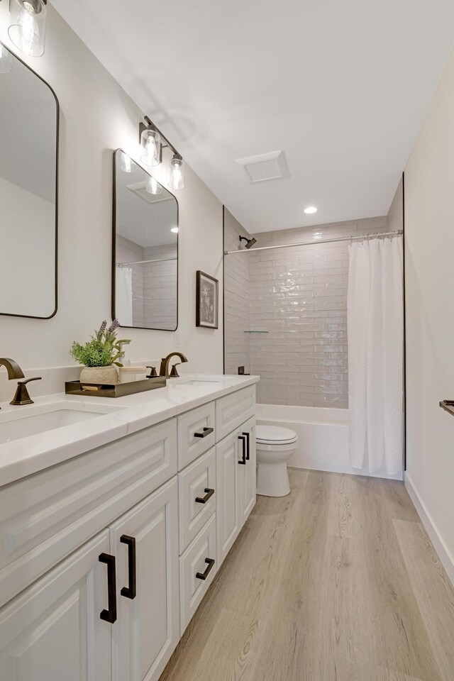 4804 12th Ave S, Minneapolis, MN 55417 - full bathroom featuring double vanity, wood finished floors, toilet, shower / tub combo with curtain, and recessed lighting