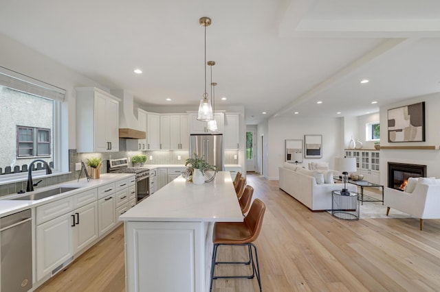 4804 12th Ave S, Minneapolis, MN 55417 - kitchen featuring premium appliances, custom range hood, a sink, decorative backsplash, and open floor plan