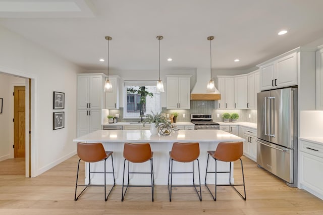 4804 12th Ave S, Minneapolis, MN 55417 - kitchen featuring appliances with stainless steel finishes, wall chimney range hood, a kitchen island, a breakfast bar, and recessed lighting
