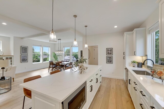4804 12th Ave S, Minneapolis, MN 55417 - kitchen with a sink, black microwave, light wood finished floors, recessed lighting, and a kitchen island