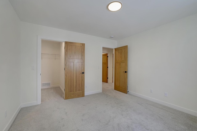 4804 12th Ave S, Minneapolis, MN 55417 - unfurnished bedroom with light carpet, baseboards, a walk in closet, and a closet