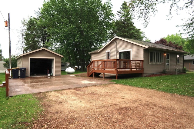663B Main St, Ellsworth, WI 54011 - back of house featuring a garage, an outbuilding, and a wooden deck