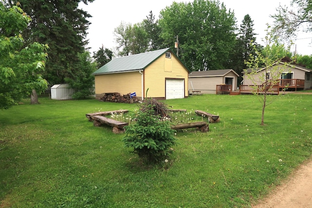 663B Main St, Ellsworth, WI 54011 - view of green lawn with an outbuilding, a garage, and a wooden deck