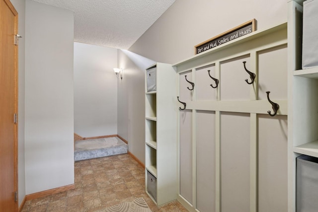 9741 Saint Andrews Dr, Elko New Market, MN 55020 - mudroom featuring baseboards, stone finish floors, and a textured ceiling