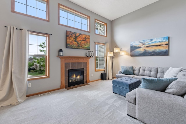 9741 Saint Andrews Dr, Elko New Market, MN 55020 - carpeted living area with baseboards, a tile fireplace, and a towering ceiling