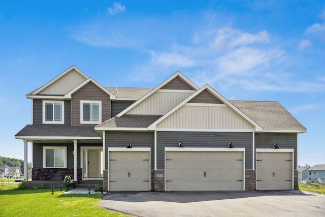 23615 Underclift St NW, Saint Francis, MN 55070 - craftsman-style house with roof with shingles, asphalt driveway, stone siding, a front lawn, and an attached garage
