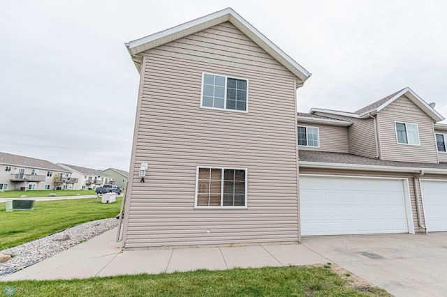 1156 42nd Ave W Unit A, West Fargo, ND 58078 - back of house featuring an attached garage, a yard, and concrete driveway