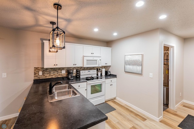 1156 42nd Ave W Unit A, West Fargo, ND 58078 - kitchen featuring white appliances, a sink, dark countertops, backsplash, and light wood finished floors