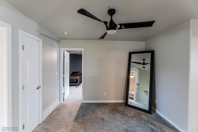 1156 42nd Ave W Unit A, West Fargo, ND 58078 - unfurnished bedroom with dark carpet, baseboards, a textured ceiling, and ceiling fan