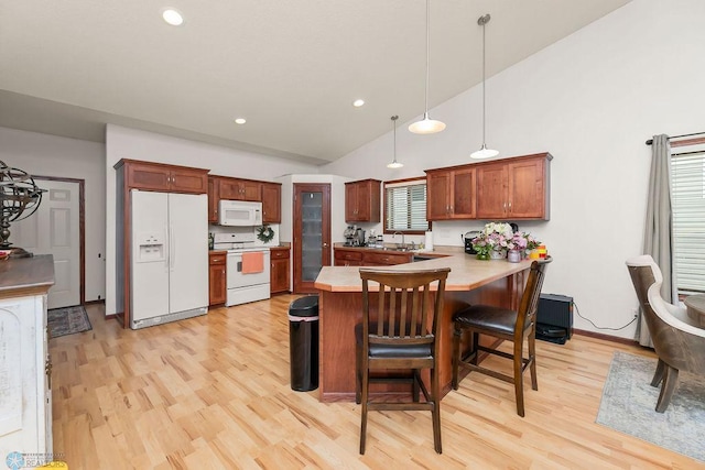 4467 53rd St S, Fargo, ND 58104 - kitchen with white appliances, a peninsula, light wood-style flooring, a sink, and a kitchen bar