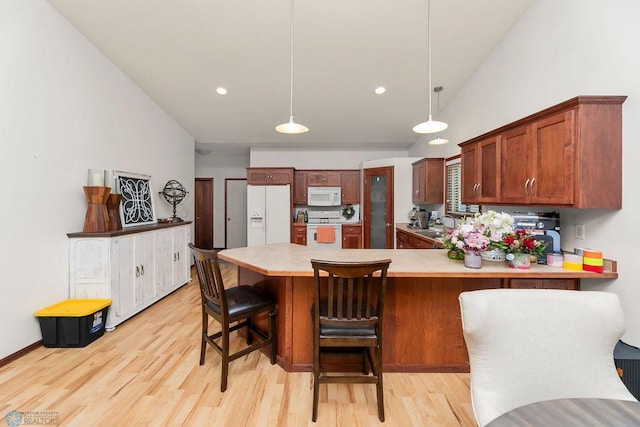 4467 53rd St S, Fargo, ND 58104 - kitchen with white appliances, a peninsula, light countertops, light wood-style flooring, and vaulted ceiling