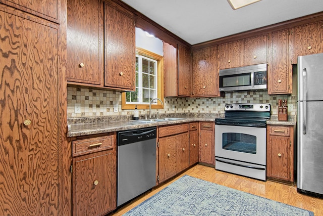 18905 Yalta St NE, East Bethel, MN 55092 - kitchen with stainless steel appliances, a sink, tasteful backsplash, and brown cabinets