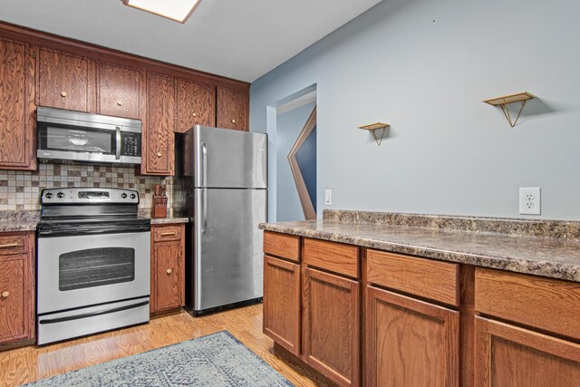 18905 Yalta St NE, East Bethel, MN 55092 - kitchen with stainless steel appliances, tasteful backsplash, and brown cabinetry