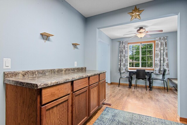 18905 Yalta St NE, East Bethel, MN 55092 - kitchen with light wood-style floors, ceiling fan, dark countertops, and brown cabinetry