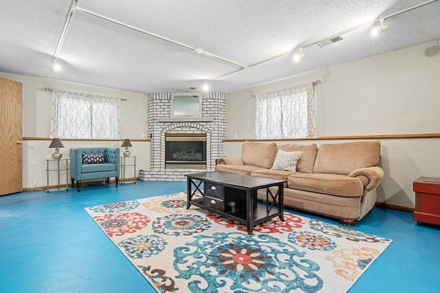 18905 Yalta St NE, East Bethel, MN 55092 - living room featuring concrete floors, healthy amount of natural light, a fireplace, a textured ceiling, and track lighting