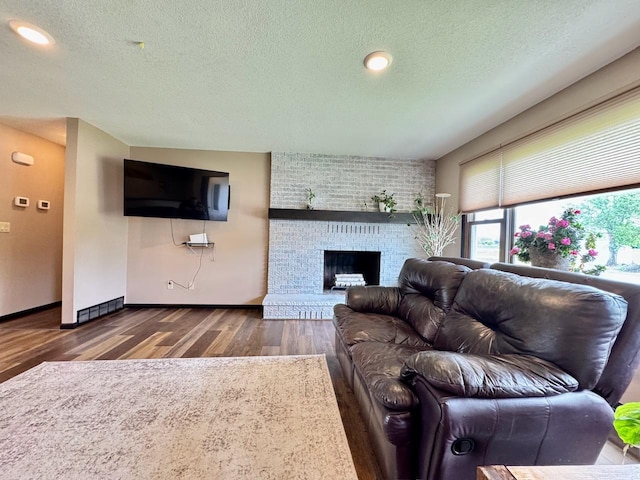 507 5th St NW, Barnesville, MN 56514 - living room with a textured ceiling, wood finished floors, a fireplace, baseboards, and recessed lighting