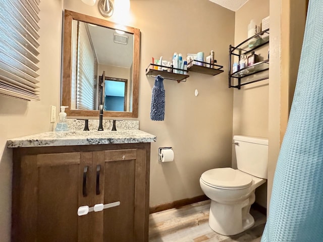 507 5th St NW, Barnesville, MN 56514 - bathroom featuring toilet, wood finished floors, vanity, and baseboards