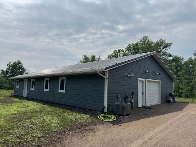 1175 Maben Ave S, Isle, MN 56342 - view of side of property featuring a metal roof, dirt driveway, and a detached garage