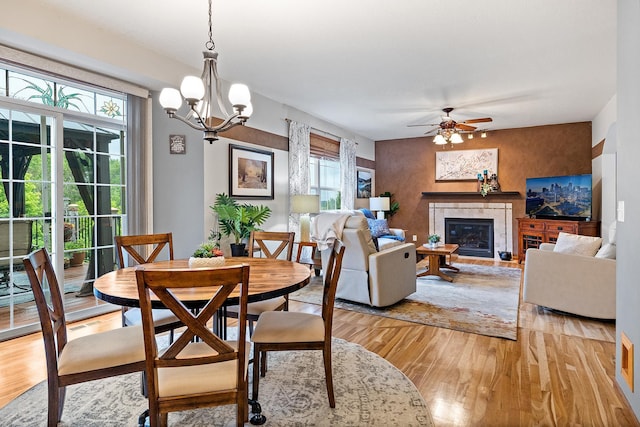 2040 Fountain Ln, Waconia, MN 55387 - dining room featuring light wood-type flooring, a tile fireplace, ceiling fan, and a chandelier