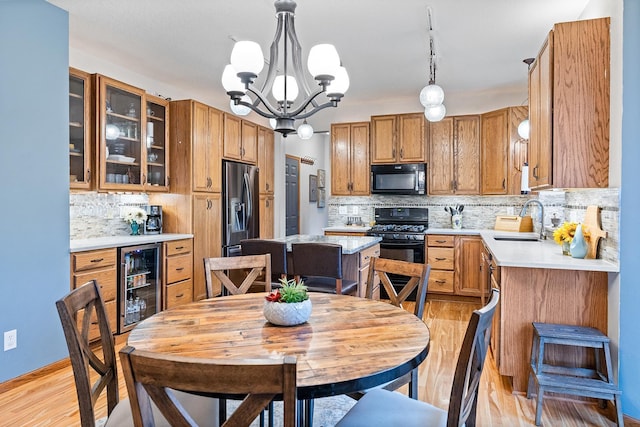 2040 Fountain Ln, Waconia, MN 55387 - kitchen featuring black appliances, beverage cooler, light wood finished floors, and decorative backsplash