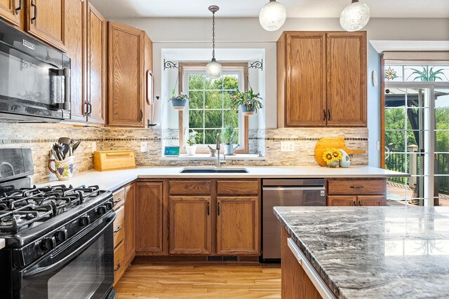 2040 Fountain Ln, Waconia, MN 55387 - kitchen featuring black appliances, hanging light fixtures, light wood-type flooring, and tasteful backsplash