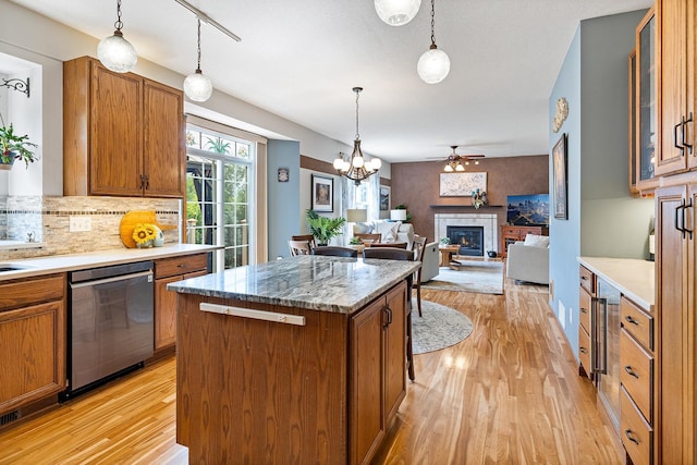 2040 Fountain Ln, Waconia, MN 55387 - kitchen with dishwasher, light wood finished floors, brown cabinetry, and a glass covered fireplace