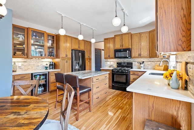 2040 Fountain Ln, Waconia, MN 55387 - kitchen featuring black appliances, beverage cooler, decorative backsplash, and light wood-style floors