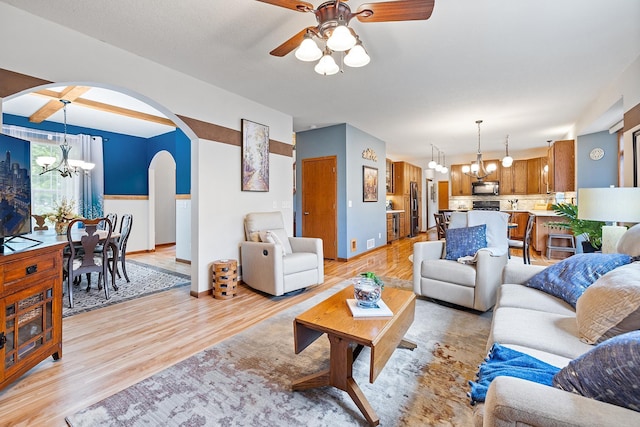 2040 Fountain Ln, Waconia, MN 55387 - living area featuring arched walkways, a chandelier, light wood-style floors, and a ceiling fan