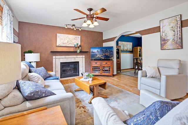2040 Fountain Ln, Waconia, MN 55387 - living room with ceiling fan, wood finished floors, arched walkways, and a tiled fireplace