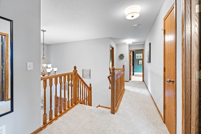 2040 Fountain Ln, Waconia, MN 55387 - hall featuring an upstairs landing, a chandelier, light colored carpet, and a textured ceiling