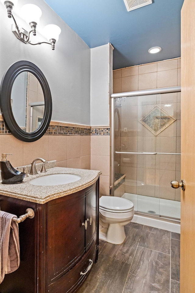 2040 Fountain Ln, Waconia, MN 55387 - full bath featuring vanity, a shower stall, tile walls, a wainscoted wall, and recessed lighting