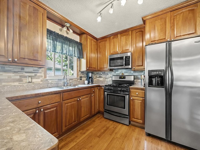 10740 99th Pl N, Maple Grove, MN 55369 - kitchen featuring appliances with stainless steel finishes, brown cabinetry, tasteful backsplash, a textured ceiling, and light wood-style floors
