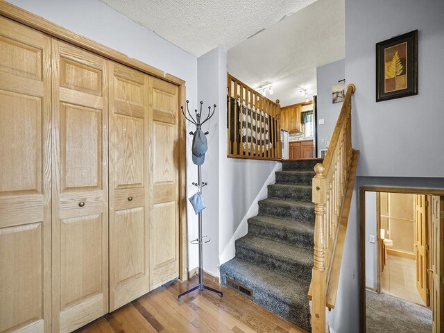 10740 99th Pl N, Maple Grove, MN 55369 - foyer featuring a textured ceiling, stairway, and wood finished floors