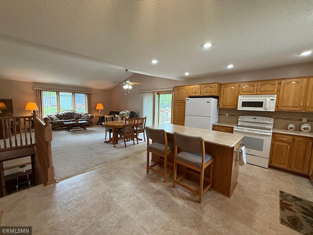 1508 Terrance Cir NE, New Prague, MN 56071 - kitchen featuring white appliances, plenty of natural light, a textured ceiling, light countertops, and a kitchen island
