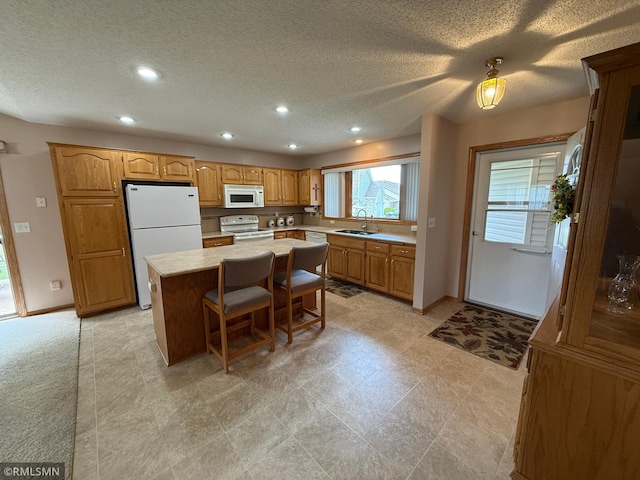 1508 Terrance Cir NE, New Prague, MN 56071 - kitchen featuring white appliances, a sink, light countertops, recessed lighting, and a center island