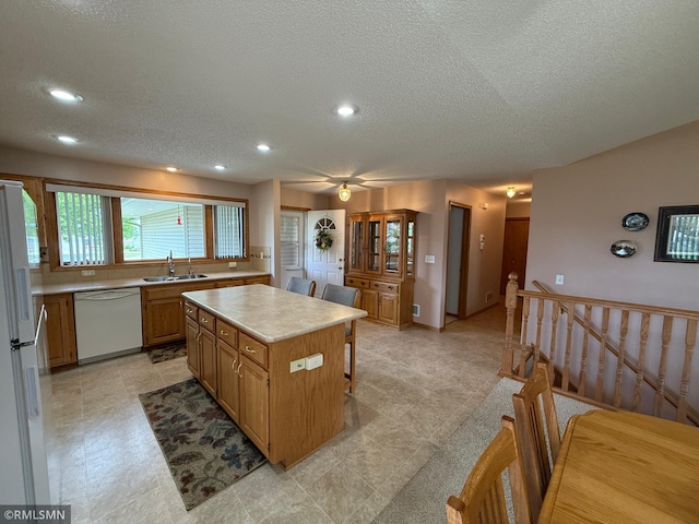 1508 Terrance Cir NE, New Prague, MN 56071 - kitchen featuring white appliances, a sink, a kitchen island, light countertops, and a textured ceiling
