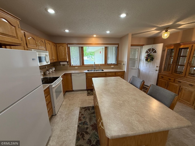 1508 Terrance Cir NE, New Prague, MN 56071 - kitchen with white appliances, a sink, a kitchen island, a textured ceiling, and light countertops
