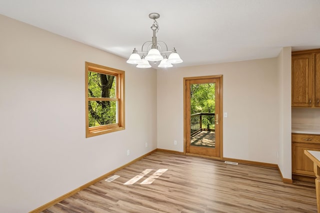 8415 Needham Ave NE, Otsego, MN 55330 - unfurnished dining area featuring light wood-style floors, a chandelier, and baseboards