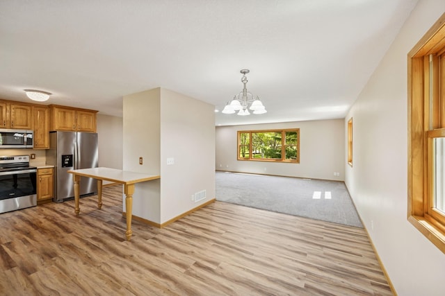 8415 Needham Ave NE, Otsego, MN 55330 - kitchen with appliances with stainless steel finishes, light wood-style floors, a chandelier, light countertops, and baseboards