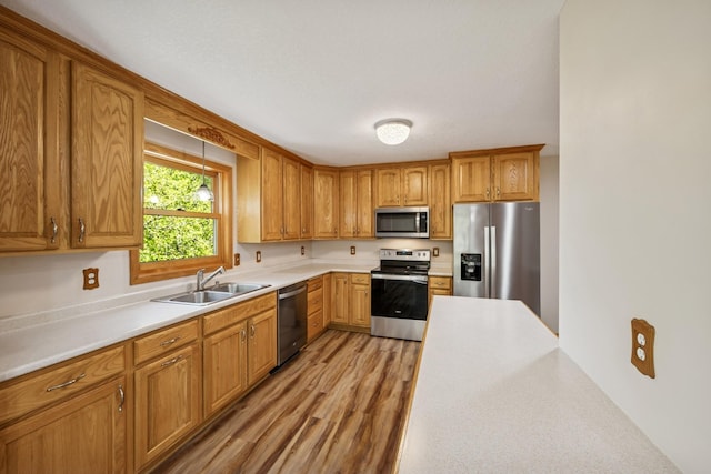 8415 Needham Ave NE, Otsego, MN 55330 - kitchen featuring appliances with stainless steel finishes, a sink, light countertops, and light wood finished floors