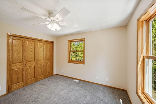 8415 Needham Ave NE, Otsego, MN 55330 - unfurnished bedroom featuring multiple windows, carpet floors, baseboards, and a ceiling fan