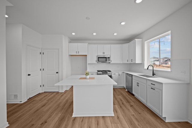 7130 Large Ave NE, Otsego, MN 55301 - kitchen featuring appliances with stainless steel finishes, a sink, light wood-style floors, decorative backsplash, and recessed lighting