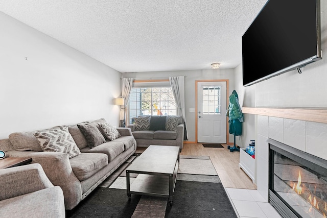 20616 Erin Way Unit 74, Farmington, MN 55024 - living room featuring a tile fireplace, a textured ceiling, and light wood-style floors
