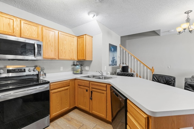 20616 Erin Way Unit 74, Farmington, MN 55024 - kitchen with appliances with stainless steel finishes, a sink, a peninsula, light countertops, and light wood finished floors