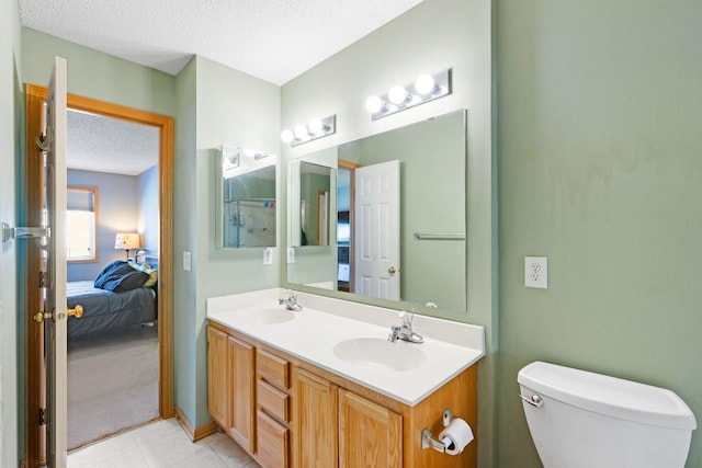 20616 Erin Way Unit 74, Farmington, MN 55024 - bathroom with a textured ceiling, connected bathroom, double vanity, tile patterned flooring, and toilet