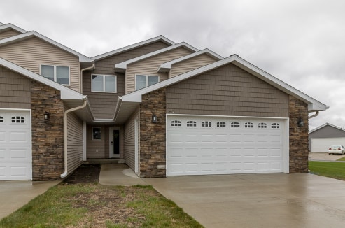 642 Haeberle Ave, New Ulm, MN 56073 - view of front of property with stone siding, driveway, and a garage