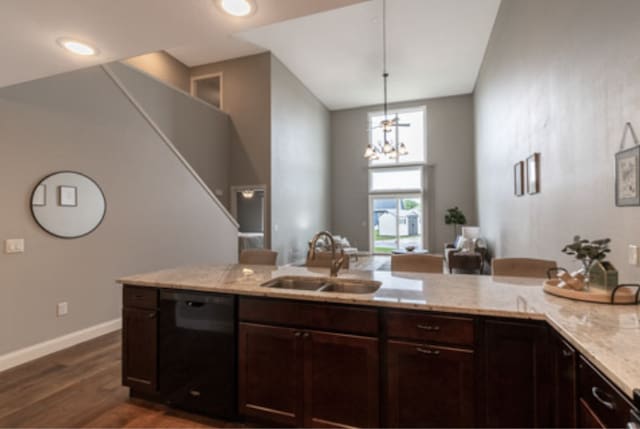 642 Haeberle Ave, New Ulm, MN 56073 - kitchen with black dishwasher, dark wood-style flooring, dark brown cabinets, light stone countertops, and hanging light fixtures