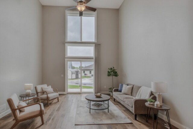 642 Haeberle Ave, New Ulm, MN 56073 - living area with plenty of natural light, a ceiling fan, light wood-type flooring, and a high ceiling